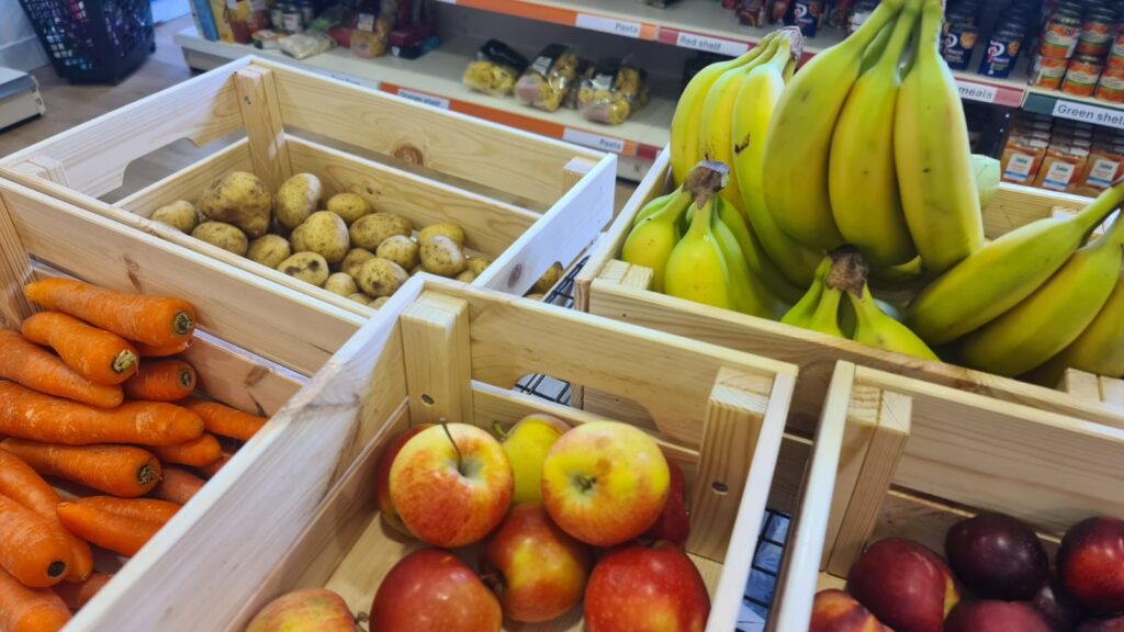 Bananas, apples, and potatoes available for foodbank clients to take. 